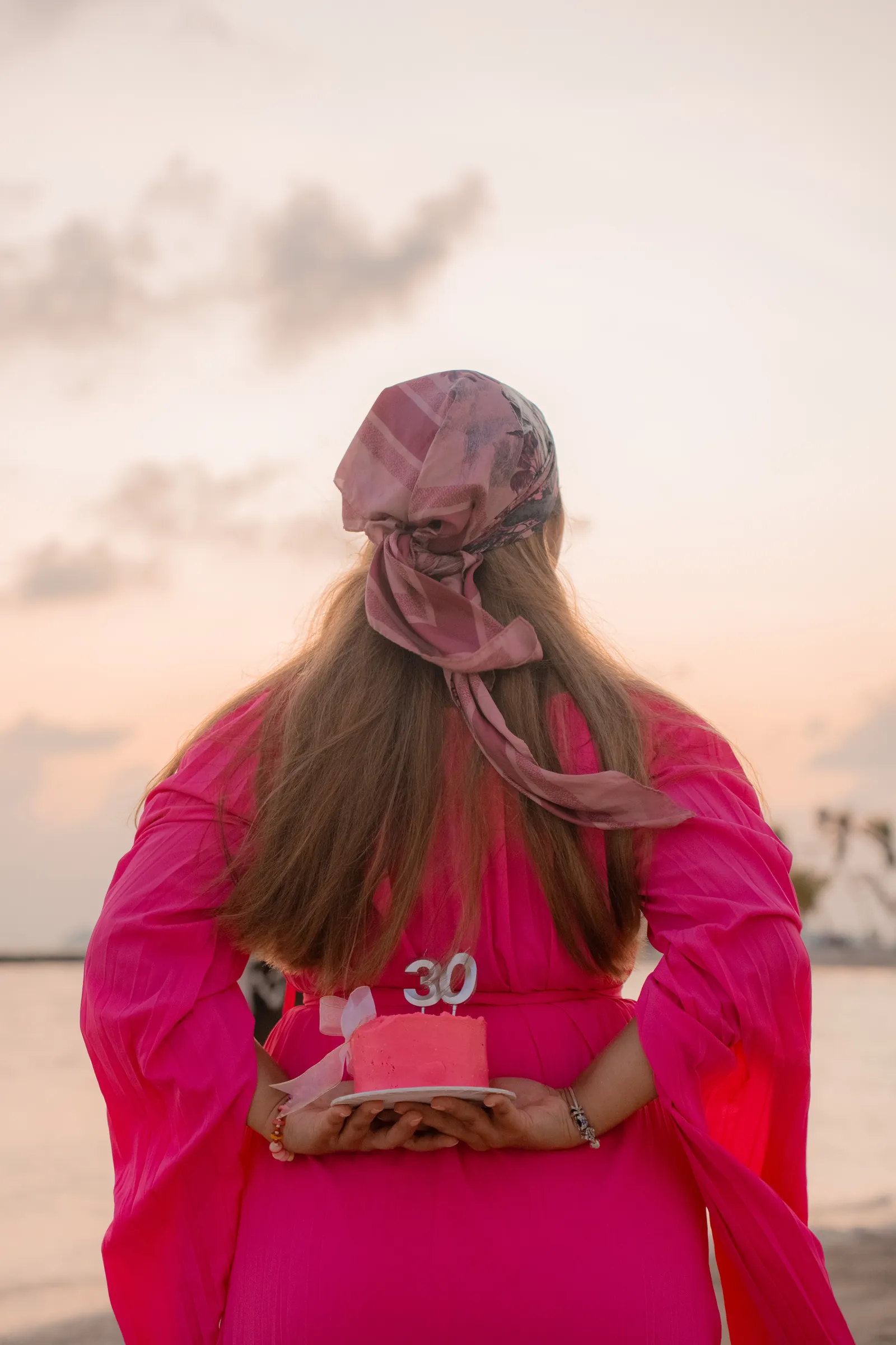 Birthday girl in pink facing the sunset