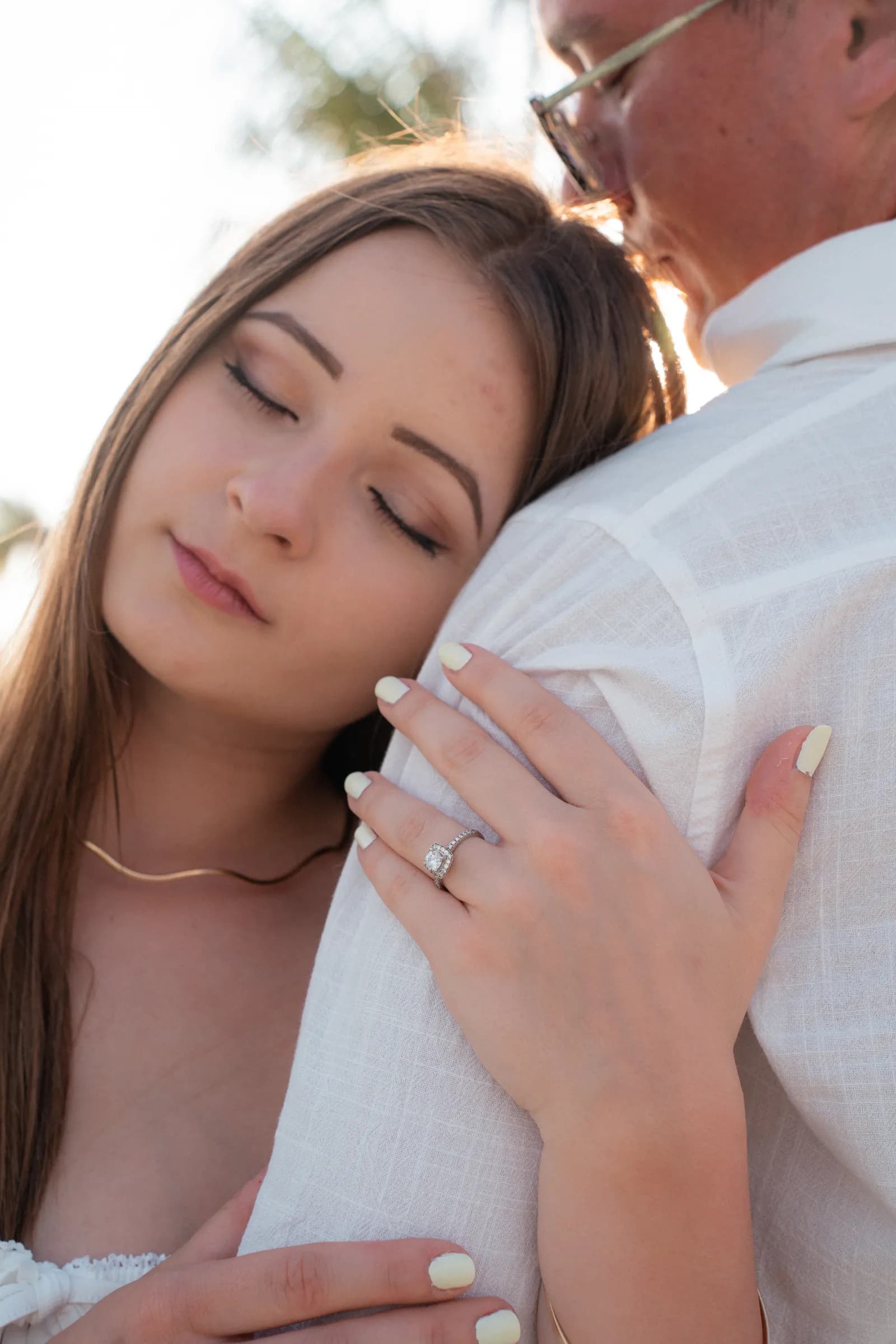 Close-up of an embrace and an engagement ring