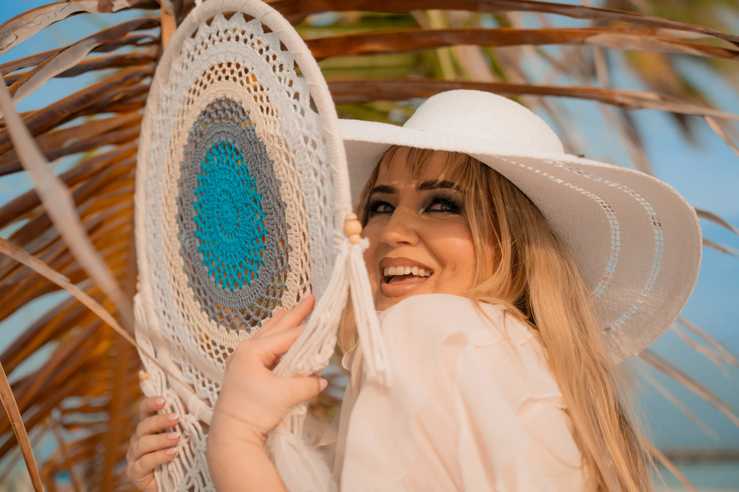 Laughing under a straw hat and dreamcatcher