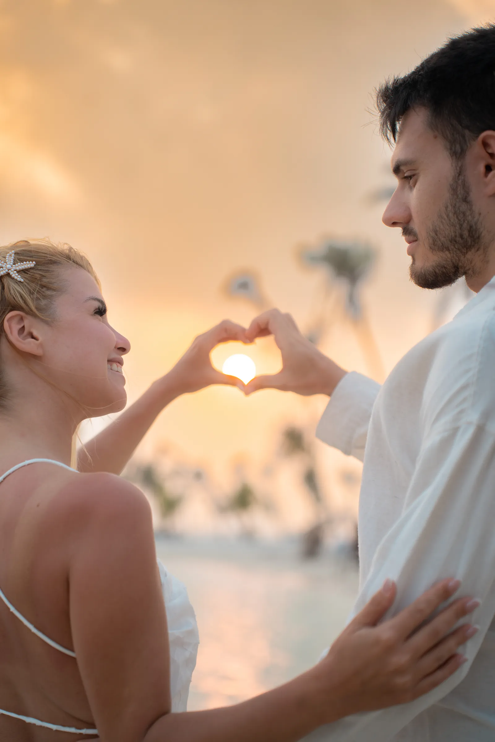Heart shape made with hands at sunset